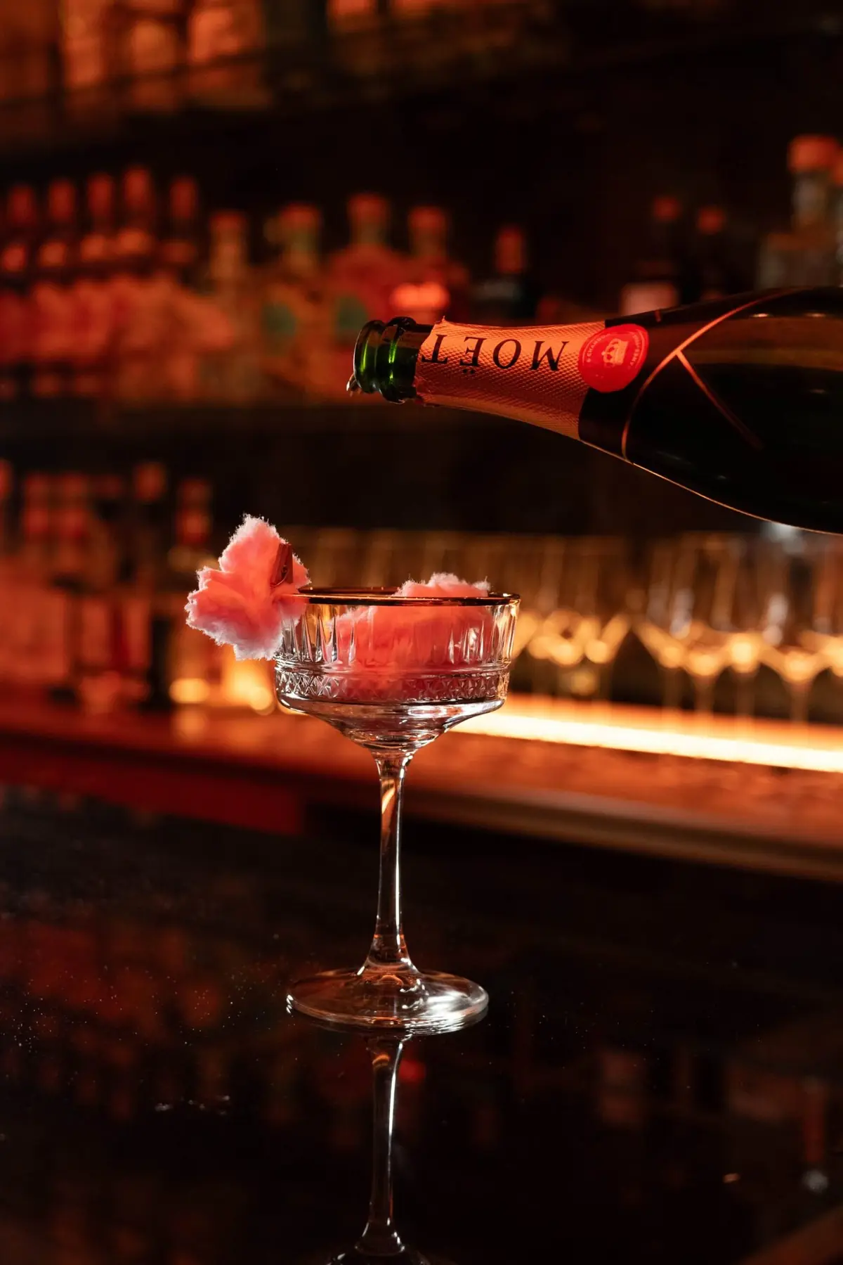 Champagne poured into a coupe at the bar