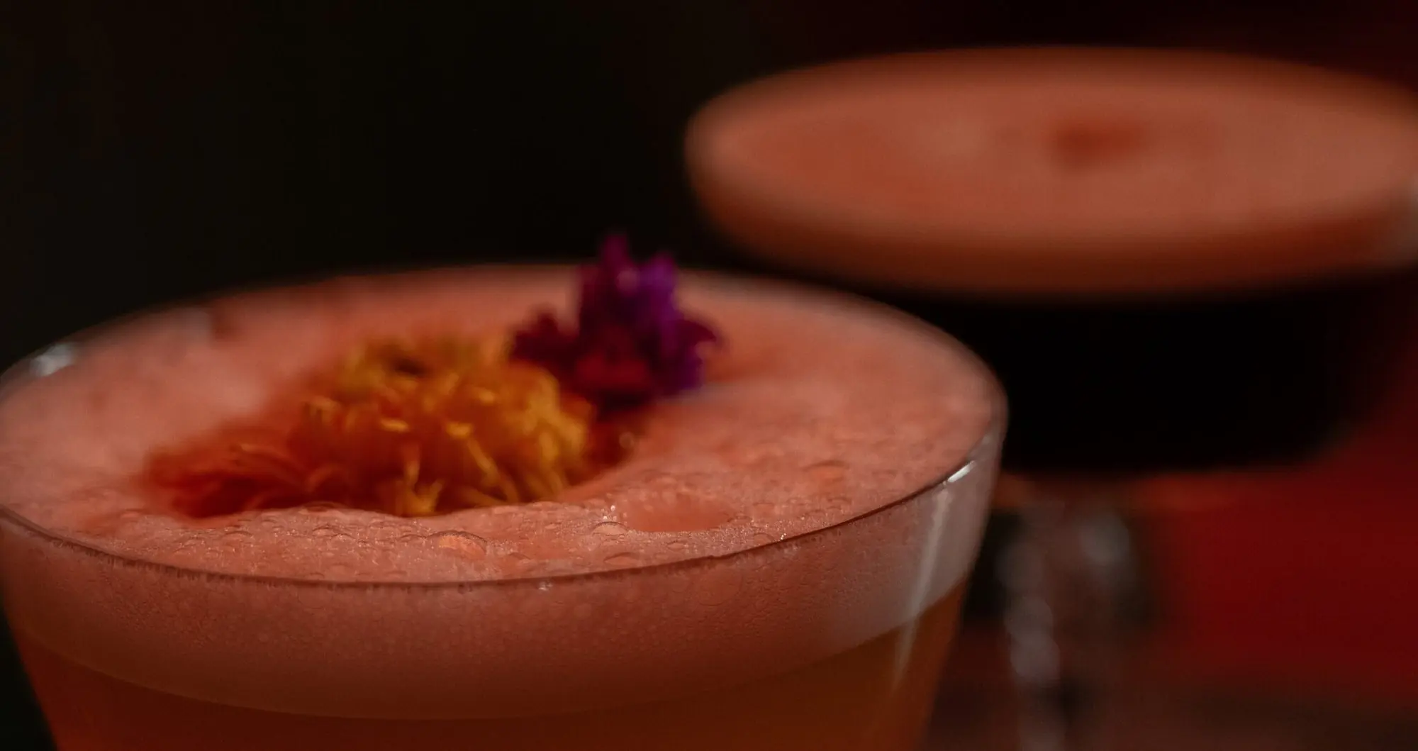 An amber serve with orange peel and a cherry
