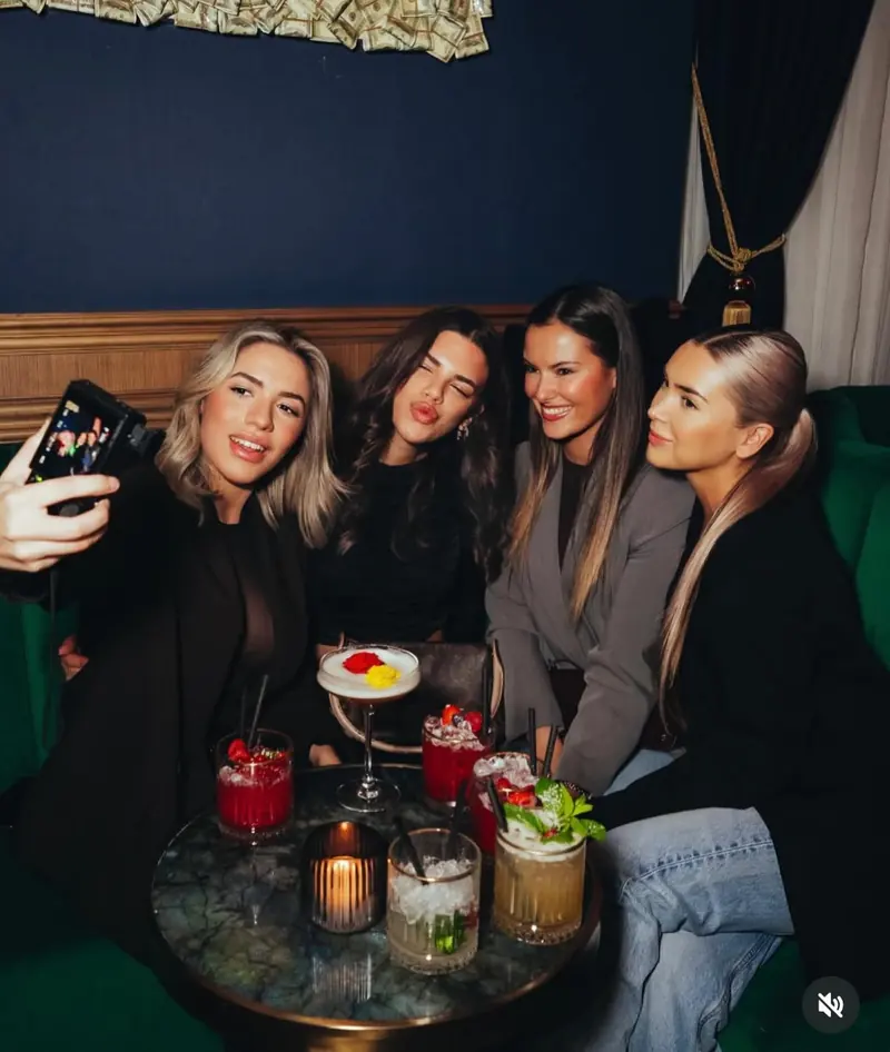 A group with cocktails at a table at Mayfair