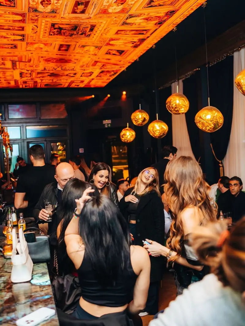 Guests under the painted ceiling at Mayfair on a busy night